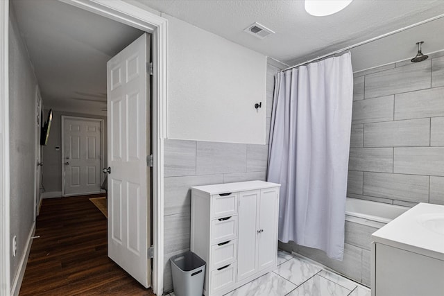 25 W Parnell St, Denison, TX 75020 - full bathroom featuring shower / tub combo with curtain, tile walls, vanity, and a textured ceiling