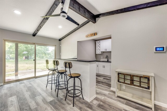 738 Campground Rd, Sherman, TX 75090 - kitchen featuring a kitchen bar, white cabinetry, dark countertops, light wood-style flooring, and recessed lighting
