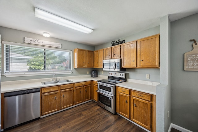 1502 Bette Dr, Mesquite, TX 75149 - kitchen featuring stainless steel appliances, light countertops, dark wood-style floors, and brown cabinets