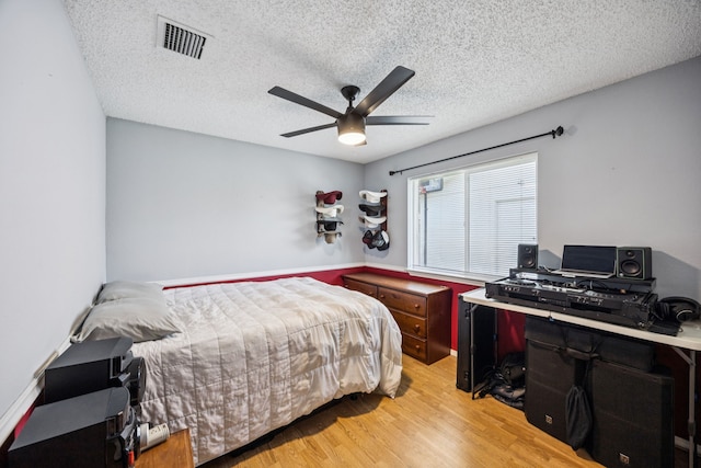 1502 Bette Dr, Mesquite, TX 75149 - bedroom featuring light wood-style flooring, an office area, a textured ceiling, and a ceiling fan