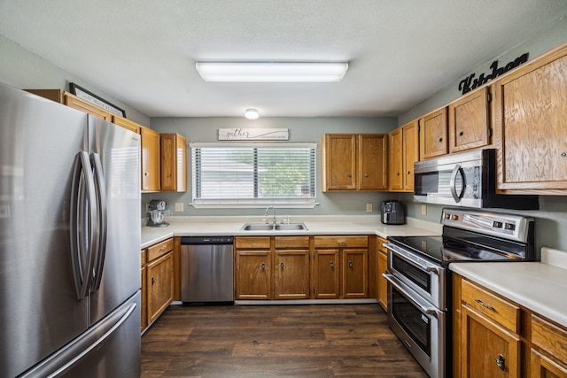 1502 Bette Dr, Mesquite, TX 75149 - kitchen with appliances with stainless steel finishes, dark wood-style flooring, light countertops, and brown cabinets
