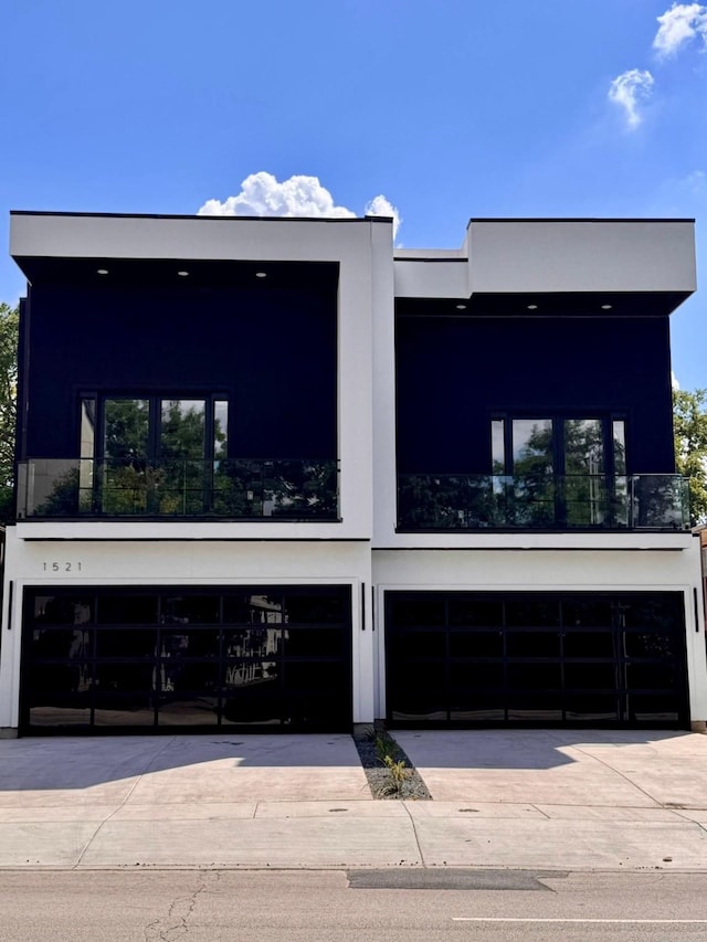 1521 N Haskell Ave, Dallas, TX 75204 - view of front facade featuring stucco siding, a garage, and driveway