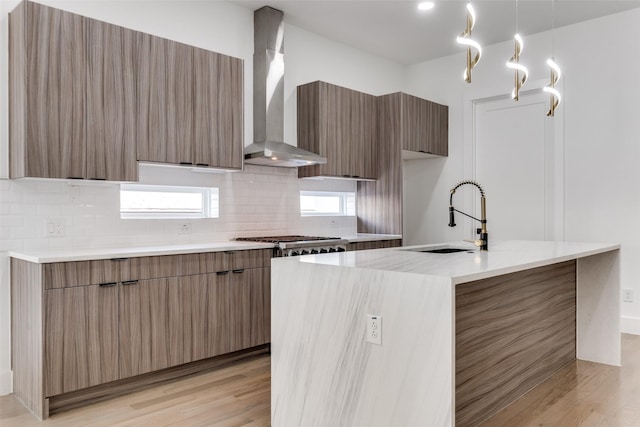 1521 N Haskell Ave, Dallas, TX 75204 - kitchen with modern cabinets, wall chimney exhaust hood, light wood finished floors, backsplash, and a center island with sink