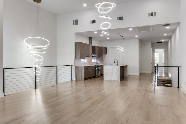 1521 N Haskell Ave, Dallas, TX 75204 - unfurnished living room featuring light wood-type flooring, a towering ceiling, and recessed lighting