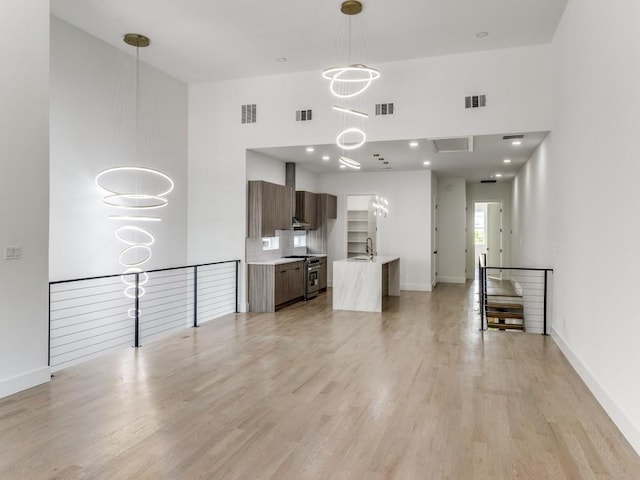 1521 N Haskell Ave, Dallas, TX 75204 - unfurnished living room with a towering ceiling and light wood-style flooring