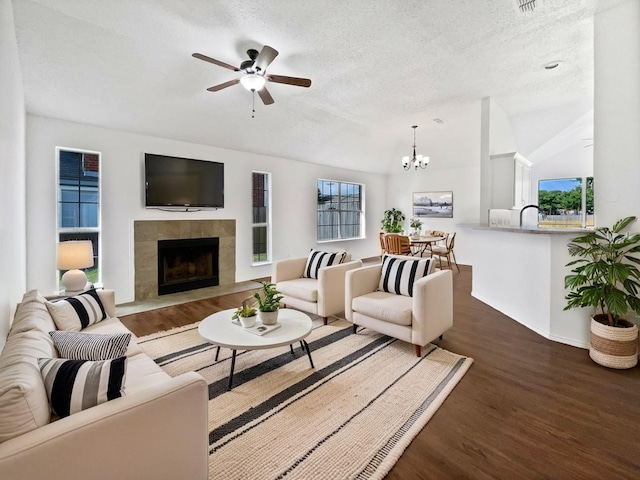 6020 Maple Leaf Dr, Arlington, TX 76017 - living area featuring wood finished floors, a fireplace, a textured ceiling, a ceiling fan, and a chandelier