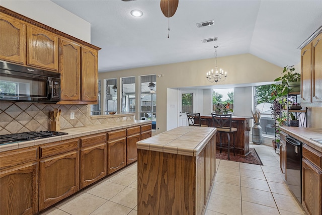 7807 Raton Ridge Ln, Arlington, TX 76002 - kitchen with black appliances, a center island, tile countertops, a ceiling fan, and tasteful backsplash
