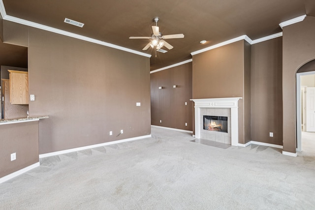 6602 Orange Blossom Dr, Midlothian, TX 76065 - unfurnished living room featuring a ceiling fan, crown molding, a tiled fireplace, and light colored carpet