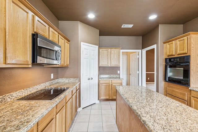 6602 Orange Blossom Dr, Midlothian, TX 76065 - kitchen featuring black appliances, light brown cabinets, light tile patterned floors, light stone counters, and recessed lighting