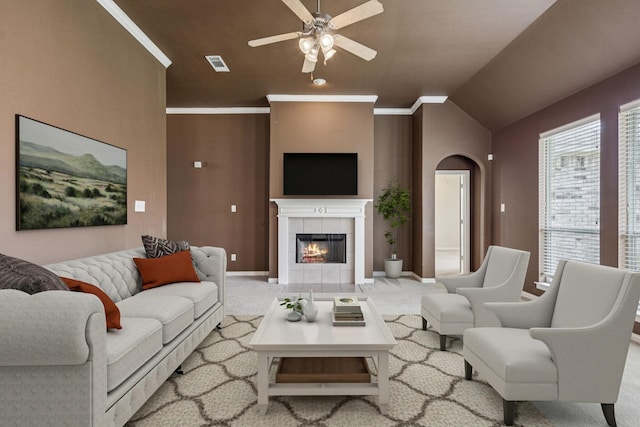 6602 Orange Blossom Dr, Midlothian, TX 76065 - carpeted living area featuring a ceiling fan, a tiled fireplace, lofted ceiling, and arched walkways