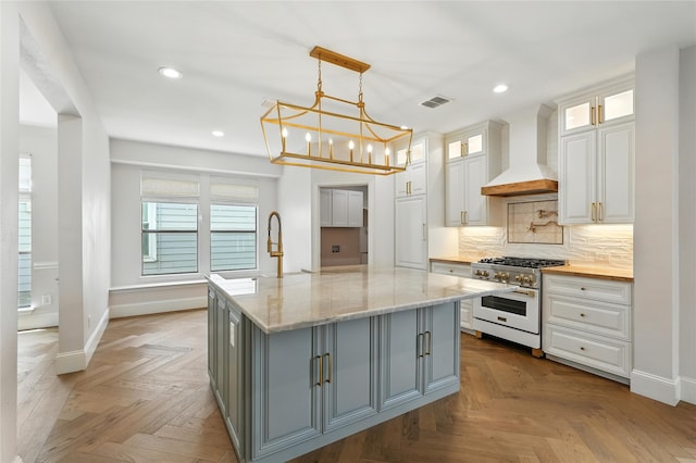 2705 Jackson Dr, Melissa, TX 75454 - kitchen with gas range oven, custom range hood, gray cabinets, recessed lighting, and white cabinetry