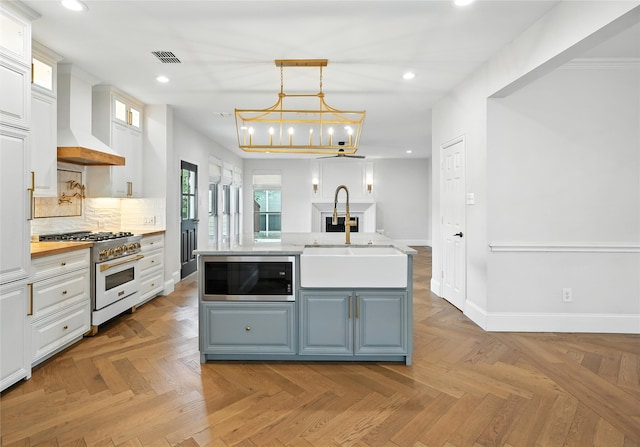 2705 Jackson Dr, Melissa, TX 75454 - kitchen with stainless steel microwave, gas stove, custom exhaust hood, white cabinetry, and recessed lighting