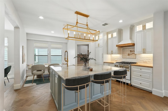 2705 Jackson Dr, Melissa, TX 75454 - kitchen with gas range, premium range hood, recessed lighting, white cabinetry, and decorative backsplash