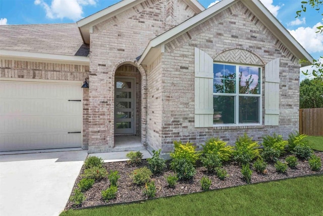 304 Ridge Dr, Justin, TX 76247 - doorway to property featuring brick siding, a garage, and concrete driveway