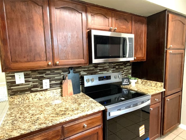 6509 Woodway Dr, Fort Worth, TX 76133 - kitchen featuring stainless steel appliances, light tile patterned flooring, tasteful backsplash, light stone counters, and brown cabinets