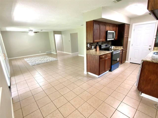 6509 Woodway Dr, Fort Worth, TX 76133 - kitchen with black range with electric cooktop, stainless steel microwave, backsplash, light tile patterned floors, and a textured ceiling