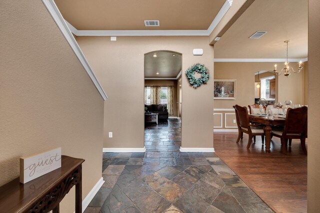 701 Champlain Ct, Midlothian, TX 76065 - entryway featuring arched walkways, crown molding, stone tile floors, and a chandelier
