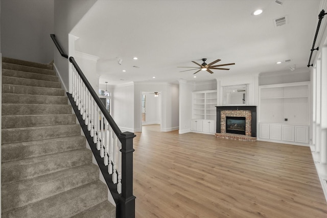 6417 Gehrig Cir, Burleson, TX 76028 - unfurnished living room with crown molding, a ceiling fan, stairs, light wood-style flooring, and recessed lighting