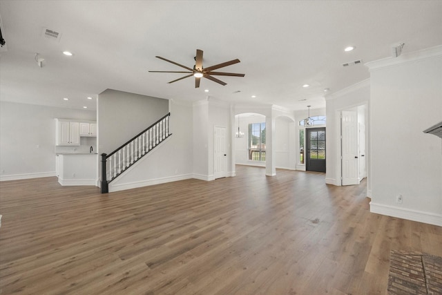 6417 Gehrig Cir, Burleson, TX 76028 - unfurnished living room with ceiling fan, arched walkways, recessed lighting, crown molding, and stairs