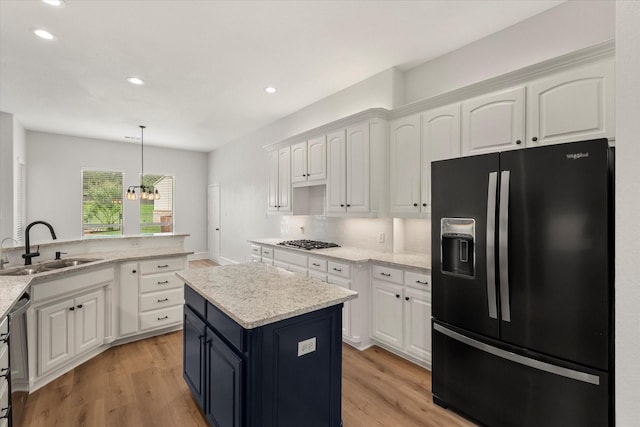 6417 Gehrig Cir, Burleson, TX 76028 - kitchen featuring stainless steel appliances, white cabinets, a center island, recessed lighting, and light wood-style flooring