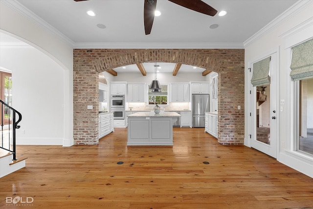 1030 Winterberry Ln, Shreveport, LA 71106 - kitchen featuring appliances with stainless steel finishes, arched walkways, ceiling fan, plenty of natural light, and brick wall