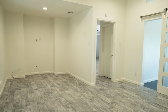 624 Mission Hills Dr, Arlington, TX 76018 - empty room with a barn door, wood finished floors, and recessed lighting