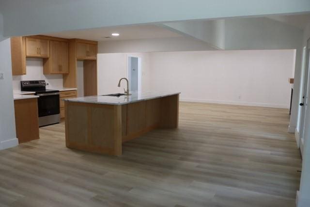 129 Oak Trl, Burleson, TX 76028 - kitchen featuring electric stove, light wood-style floors, light countertops, open floor plan, and a center island with sink