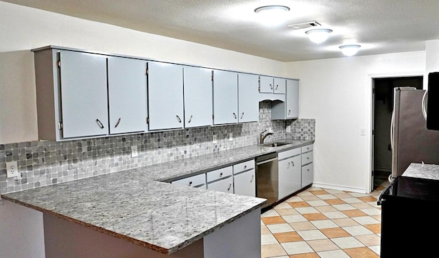 3429 Willowcrest Dr, North Richland Hills, TX 76117 - kitchen featuring appliances with stainless steel finishes, decorative backsplash, a peninsula, a textured ceiling, and light stone countertops