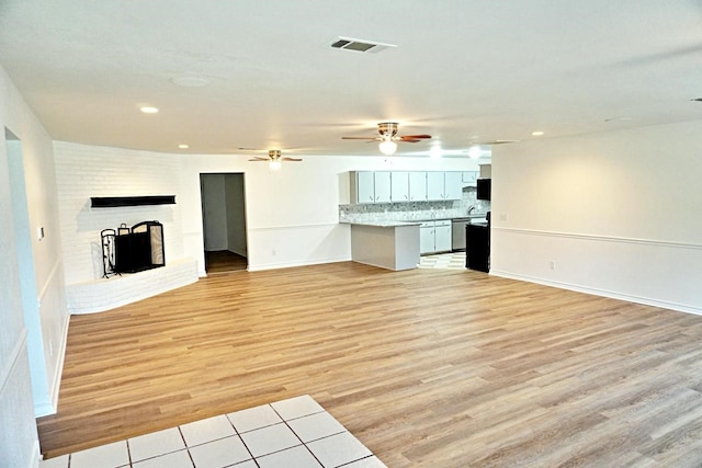 3429 Willowcrest Dr, North Richland Hills, TX 76117 - unfurnished living room with light wood-style floors, a fireplace, recessed lighting, and a ceiling fan
