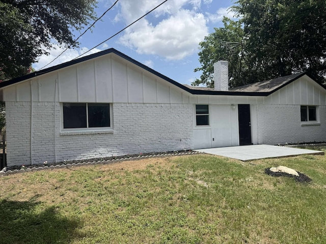 3429 Willowcrest Dr, North Richland Hills, TX 76117 - rear view of house with board and batten siding, brick siding, a chimney, a patio area, and a yard