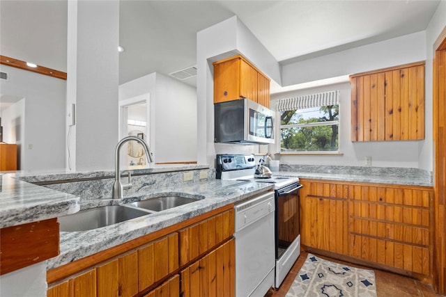 3125 County Road 264, Breckenridge, TX 76424 - kitchen featuring white appliances, light stone counters, and brown cabinetry