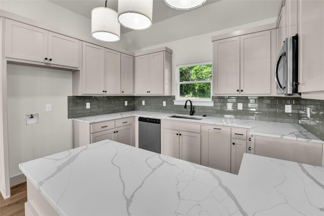 1604 Franklin St, Weatherford, TX 76086 - kitchen featuring appliances with stainless steel finishes, light stone countertops, tasteful backsplash, light wood-type flooring, and hanging light fixtures