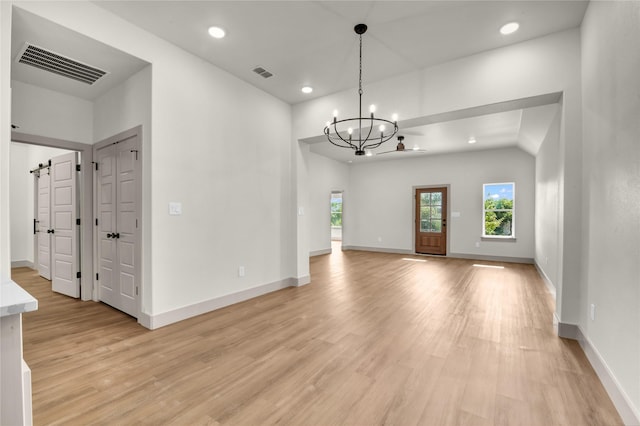 1604 Franklin St, Weatherford, TX 76086 - unfurnished living room featuring healthy amount of natural light, light wood-type flooring, a chandelier, recessed lighting, and a barn door