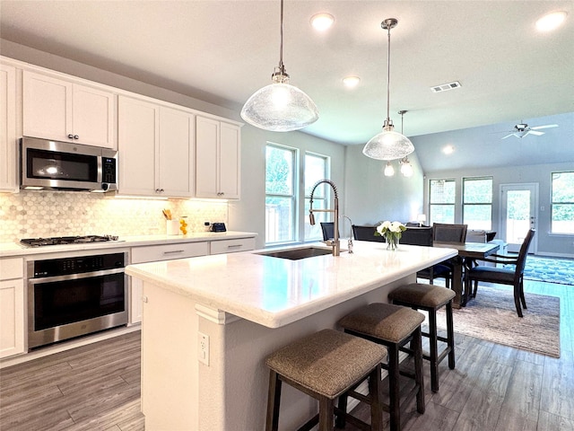7204 Silent Mill Rd, Arlington, TX 76001 - kitchen with appliances with stainless steel finishes, recessed lighting, light wood-type flooring, tasteful backsplash, and hanging light fixtures