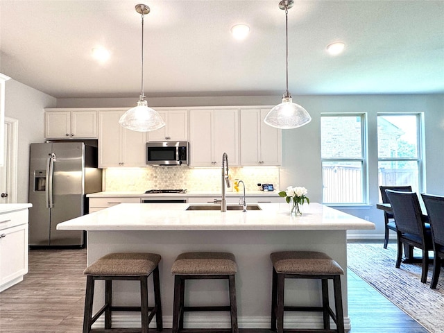 7204 Silent Mill Rd, Arlington, TX 76001 - kitchen with appliances with stainless steel finishes, decorative backsplash, a kitchen bar, decorative light fixtures, and recessed lighting