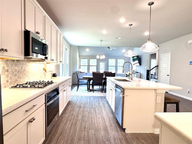 7204 Silent Mill Rd, Arlington, TX 76001 - kitchen featuring stainless steel appliances, dark wood-style flooring, a ceiling fan, decorative backsplash, and a breakfast bar