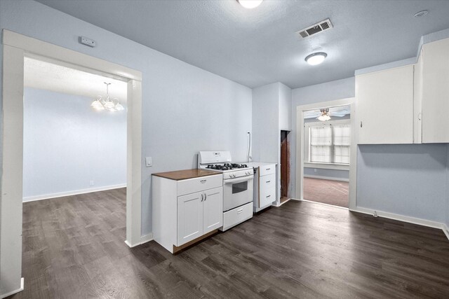 318 Mckenzie St, Waxahachie, TX 75165 - kitchen with white gas range oven, dark wood-style flooring, a chandelier, white cabinetry, and ceiling fan