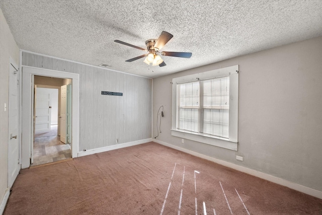 318 Mckenzie St, Waxahachie, TX 75165 - empty room with ceiling fan, carpet flooring, a textured ceiling, and wooden walls
