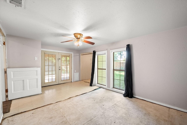 318 Mckenzie St, Waxahachie, TX 75165 - empty room with french doors, a ceiling fan, and a textured ceiling