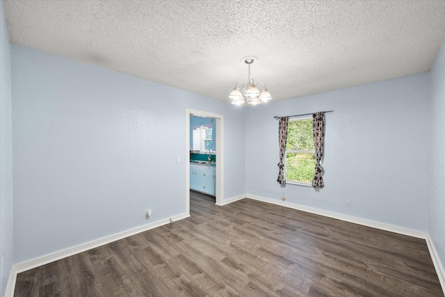 318 Mckenzie St, Waxahachie, TX 75165 - spare room featuring a chandelier, dark wood finished floors, and a textured ceiling