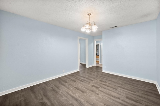 318 Mckenzie St, Waxahachie, TX 75165 - spare room with a chandelier, dark wood-style floors, and a textured ceiling