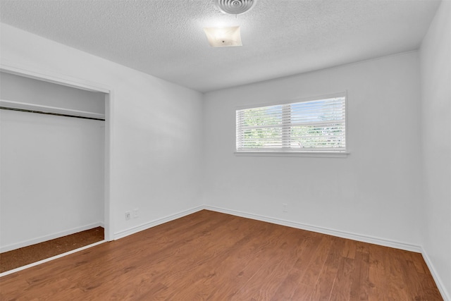 5624 Waltham Ave, Fort Worth, TX 76133 - unfurnished bedroom with wood finished floors, a textured ceiling, and a closet