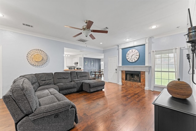3227 Baskin Dr, Lancaster, TX 75134 - living area featuring a ceiling fan, crown molding, wood finished floors, a tiled fireplace, and recessed lighting