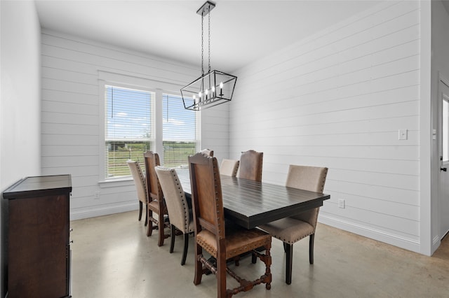 177 Mel Dr, Woodway, TX 76712 - dining room with a chandelier, concrete floors, and wooden walls