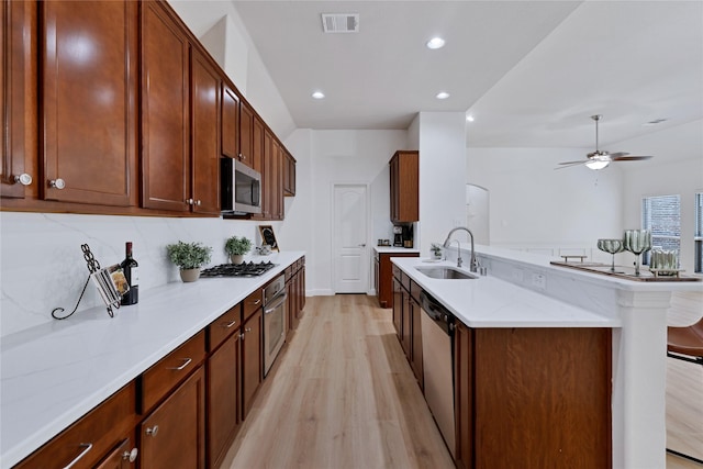 7064 Dreammaker Way, Frisco, TX 75035 - kitchen featuring light wood-style flooring, appliances with stainless steel finishes, light stone countertops, ceiling fan, and recessed lighting