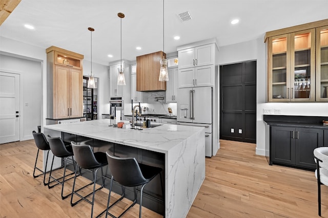 2028 Fox Bend Trce, Gunter, TX 75058 - kitchen with high end fridge, a center island with sink, light wood-style floors, light stone countertops, and recessed lighting