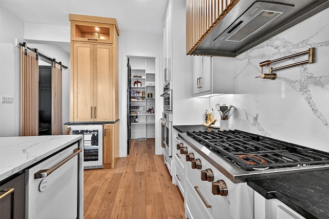 2028 Fox Bend Trce, Gunter, TX 75058 - kitchen featuring exhaust hood, wine cooler, stainless steel appliances, light wood-type flooring, and light stone countertops