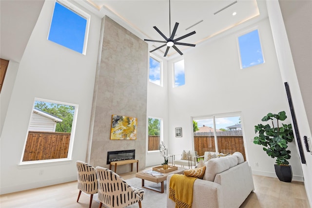 1706 Homeland St, Dallas, TX 75212 - living area with a towering ceiling, a tiled fireplace, light wood finished floors, and plenty of natural light