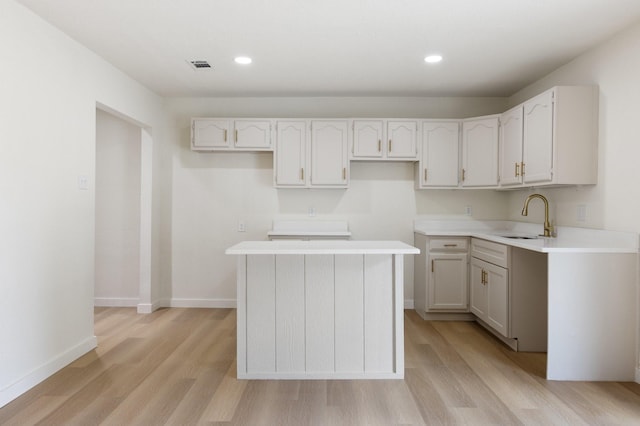 719 Sara Dr, Mesquite, TX 75149 - kitchen with light wood-style flooring, a center island, recessed lighting, and light countertops