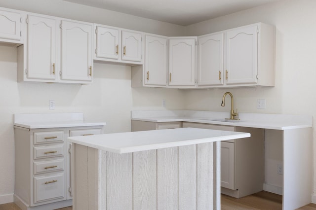 719 Sara Dr, Mesquite, TX 75149 - kitchen featuring white cabinetry, light wood finished floors, a center island, and light countertops